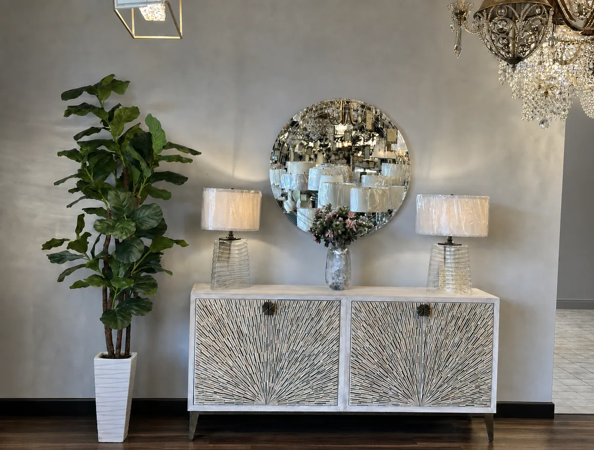 Console table with a round mirror, two glass table lamps and a fiddle-leaf tree in the Williams Electric Supply decor showroom